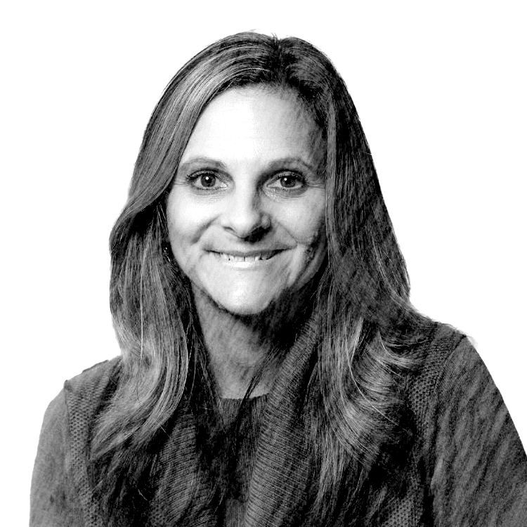 A black and white photo of a smiling woman with long hair and a sweater.