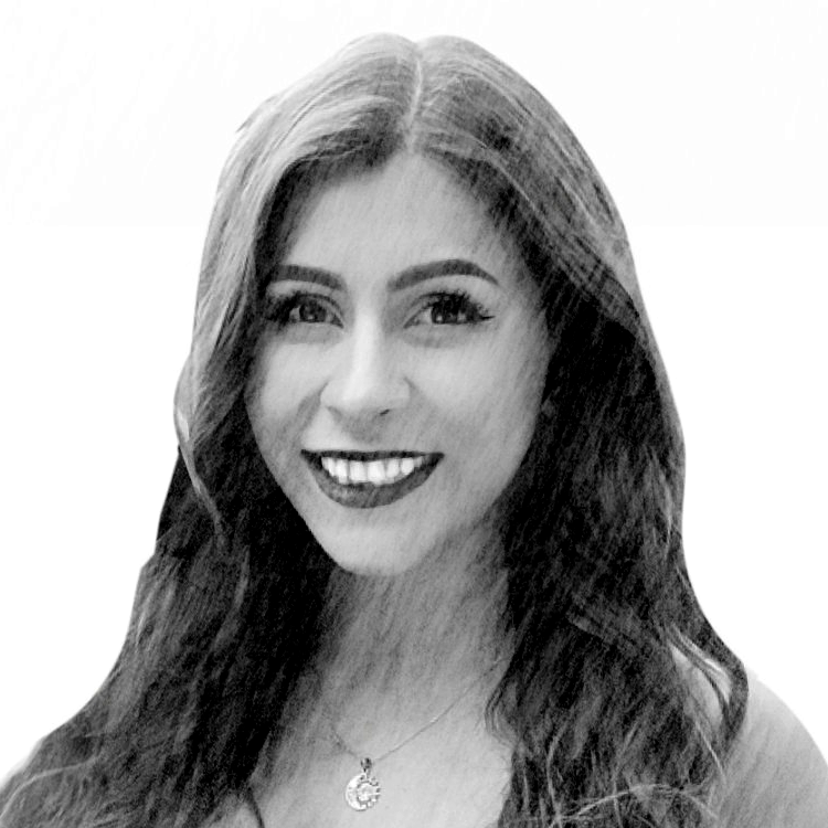 Black and white photo of a smiling woman with long hair and a necklace.