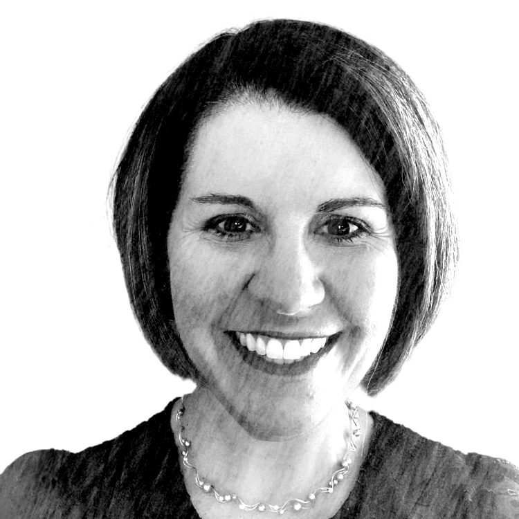 A black and white portrait of a smiling woman with short hair and a necklace.