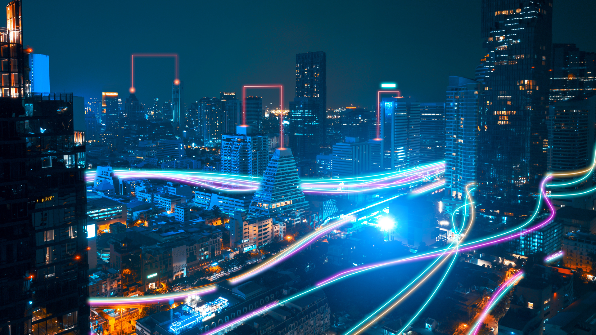 A night cityscape with neon lights highlighting building contours and vibrant streaks suggesting futuristic transportation paths.