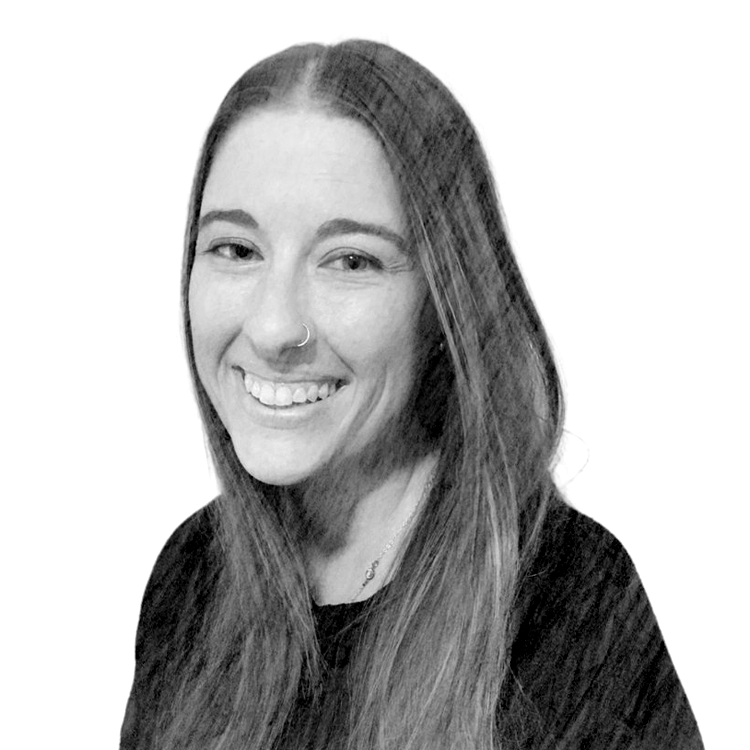 Black and white photo of a smiling woman with long hair and a nose ring.