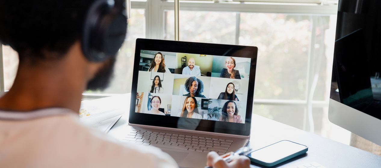 A person attending a virtual meeting with multiple participants on their laptop screen.