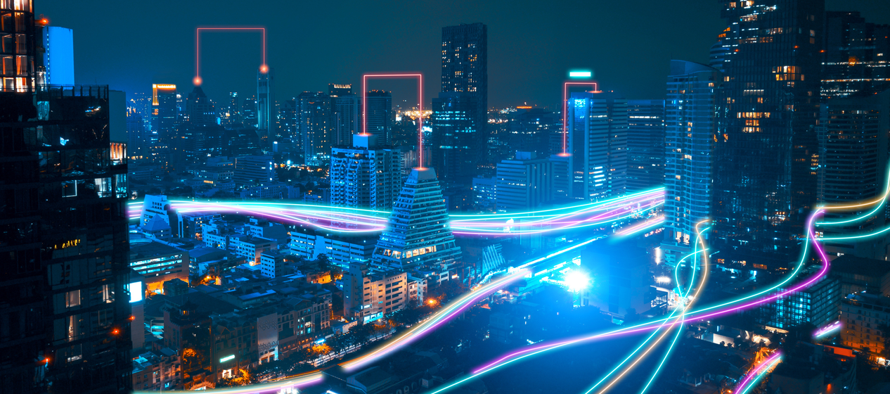 A night cityscape with neon lights highlighting building contours and vibrant streaks suggesting futuristic transportation paths.